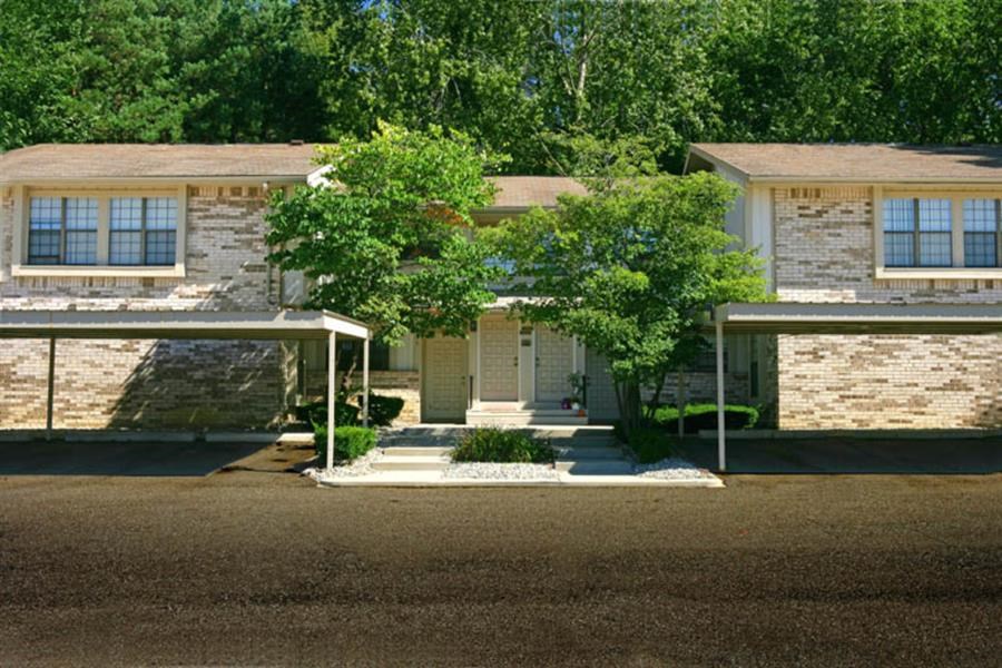 a white brick house with trees in front of it