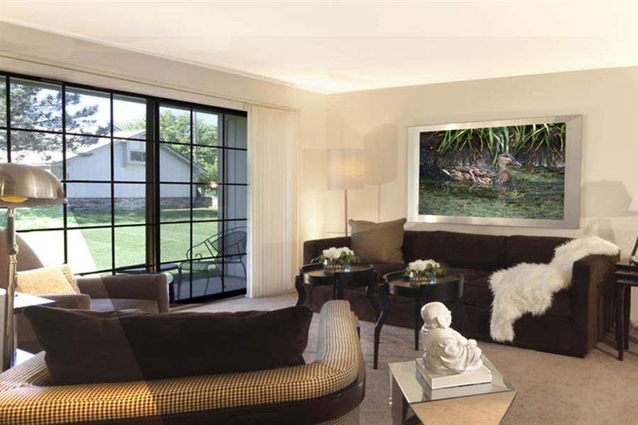 a living room with couches and chairs and a painting on the wall