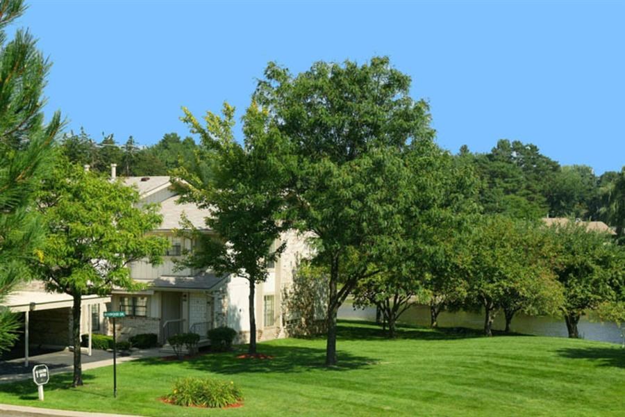 a yard with trees in front of a house