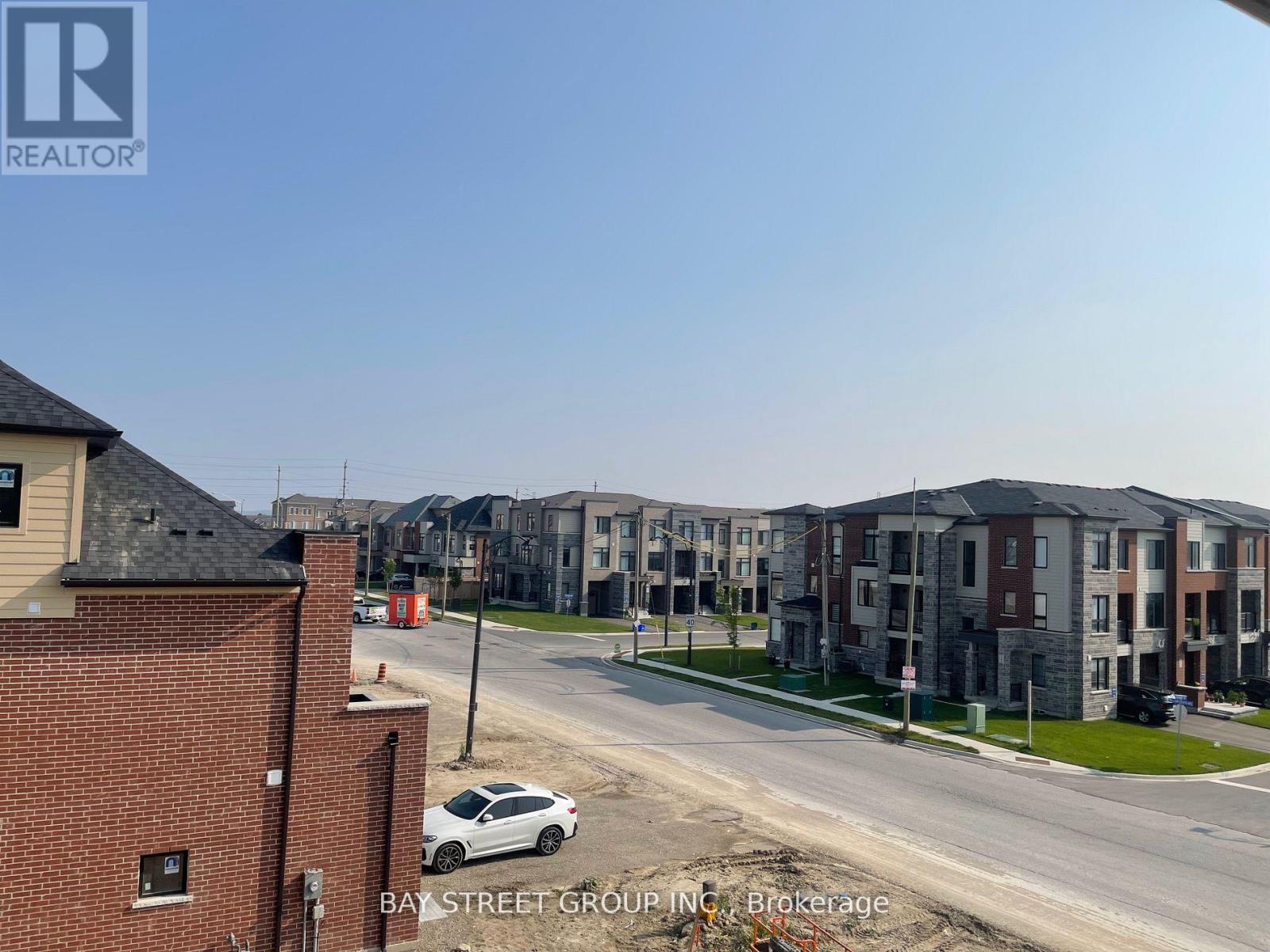 A view of a street with apartment buildings and a car parked on the side of the road.