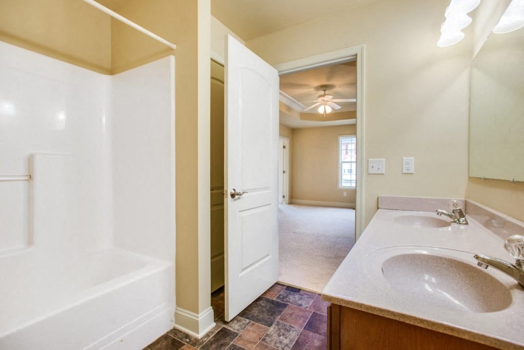 A bathroom with a white tub and sink.