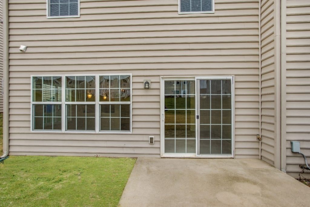 A house with a grey siding and a glass door.