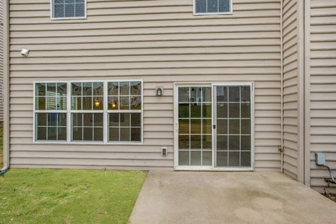 A house with a grey siding and a glass door.