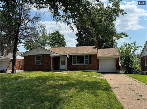 A red brick house with a white garage door and a brown roof.