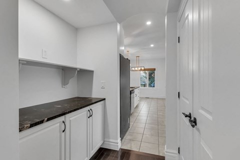 A kitchen with white cabinets and a black countertop.