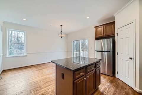 A kitchen with wooden cabinets and a black countertop.