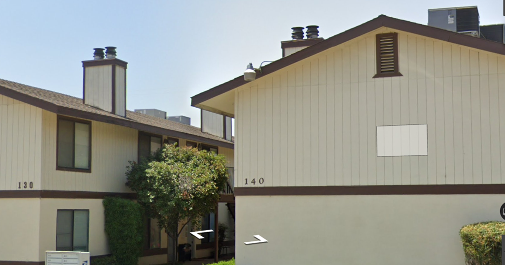 A building with a brown roof and a white sign that says 130.