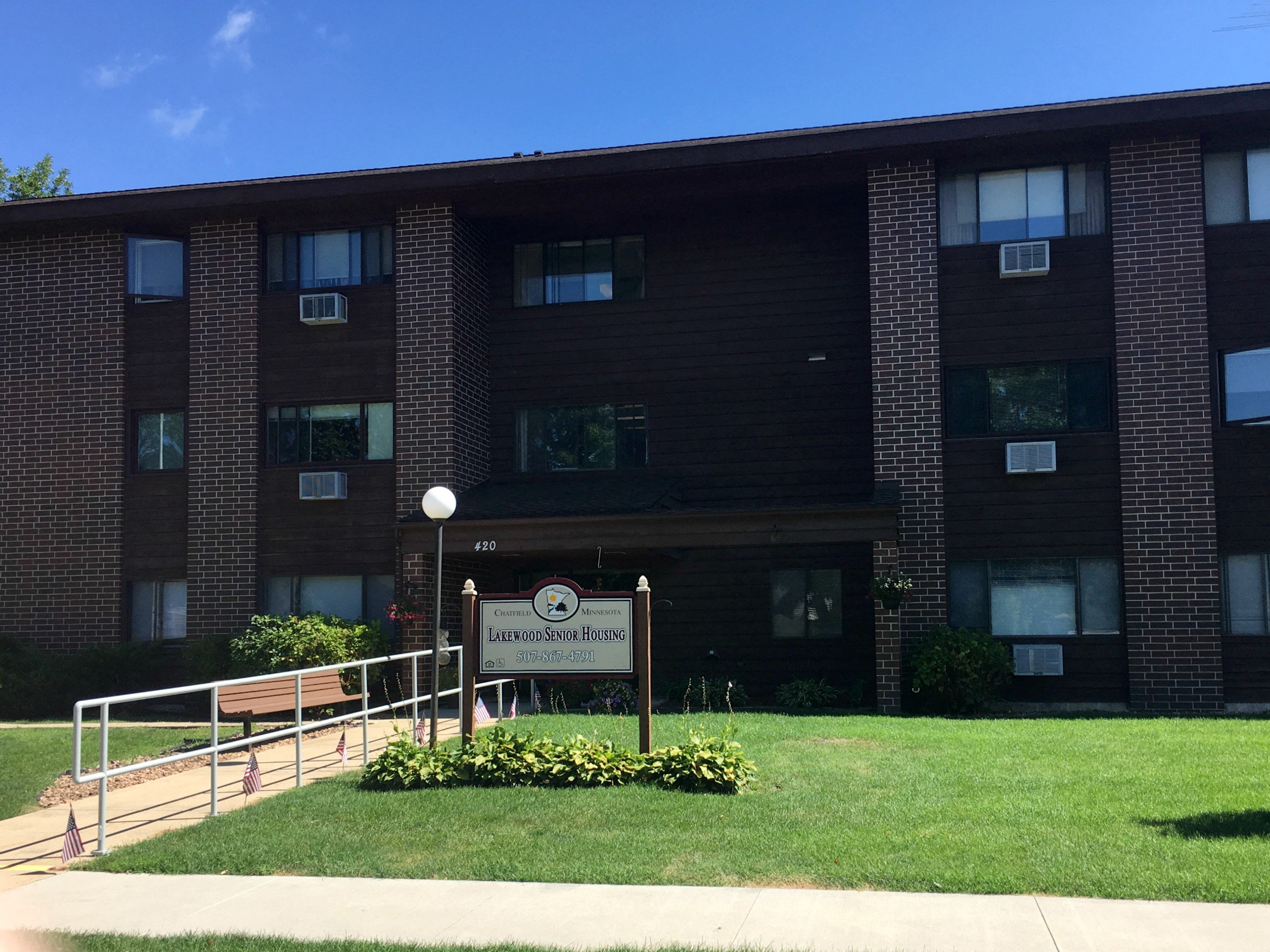 A brick building with a sign that says "Lourdes Housing".