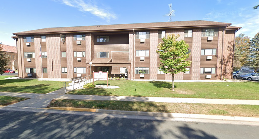 apartment building with grass and trees