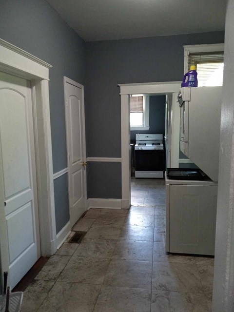 A kitchen with a white refrigerator and a white door.