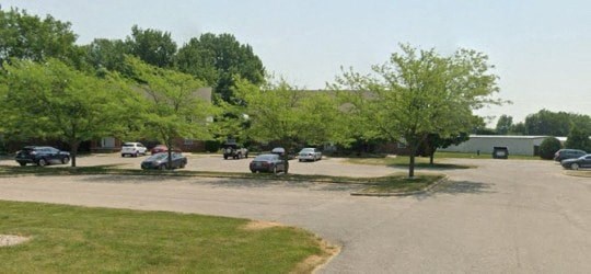 A parking lot with cars and trees.