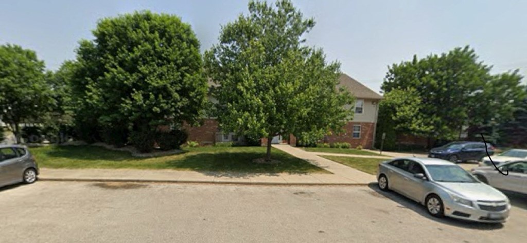 A silver car is parked in a driveway.
