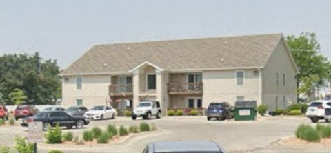 A large building with a parking lot in front.