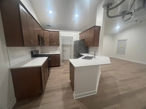 A kitchen with brown cabinets and a white island.