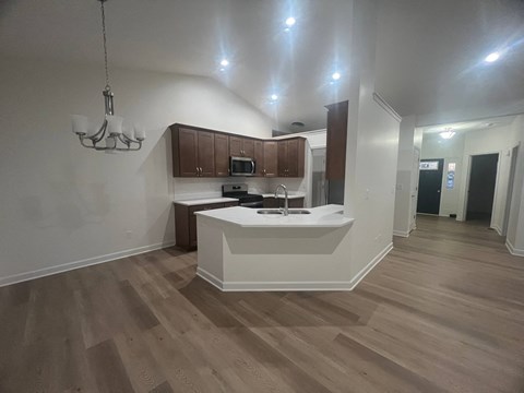 A kitchen with wooden floors and a white counter.