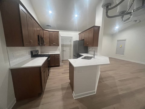 A kitchen with brown cabinets and a white island.