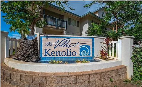 A sign for The Villas at Kenolio in front of a building.