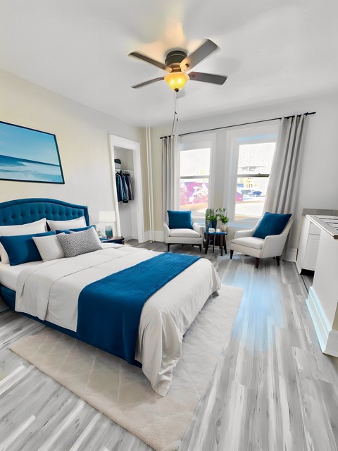 A bedroom with a large bed and a ceiling fan.