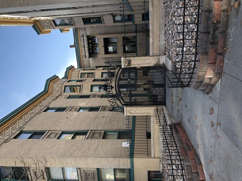 A tall building with a balcony and a fire escape.