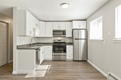 A kitchen with white cabinets and stainless steel appliances.