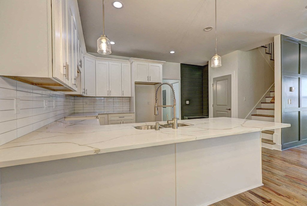 A modern kitchen with white cabinets and a large island.