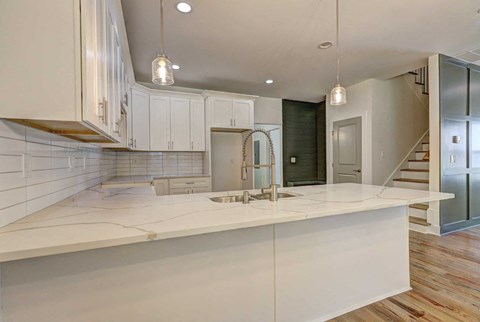 A modern kitchen with white cabinets and a large island.