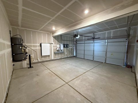 A spacious garage with a concrete floor and white walls.
