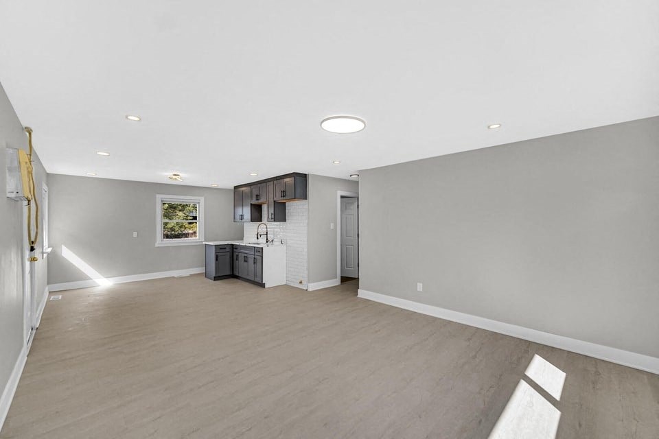 A spacious room with a cabinet and a window.