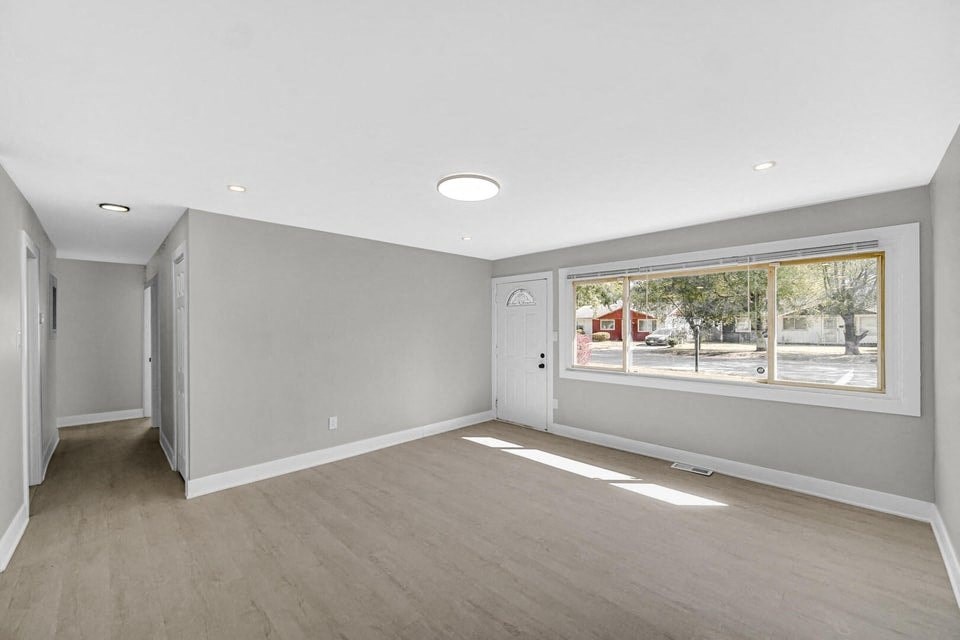 A spacious room with a large window and a view of the city.