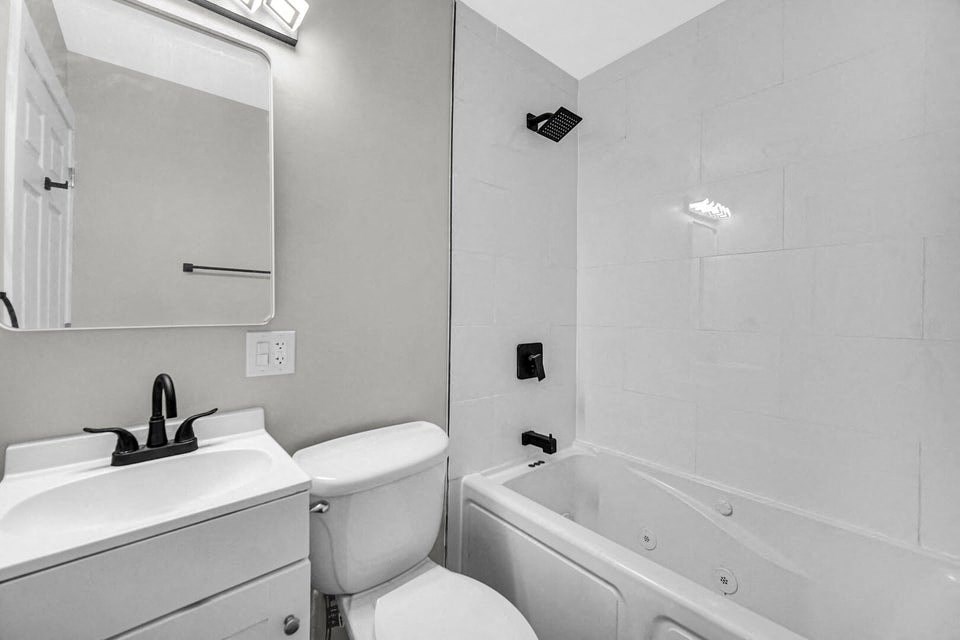 A white bathroom with a toilet, sink, and bathtub.