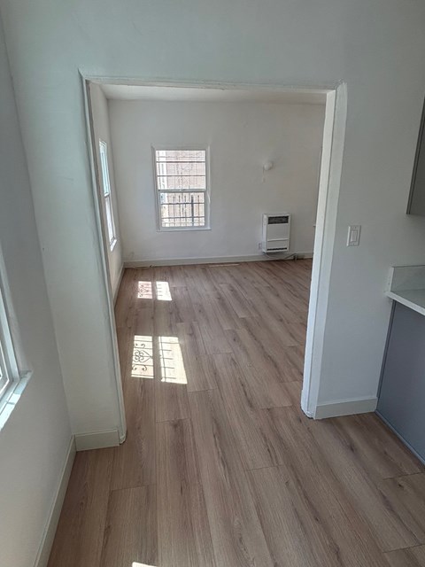 A room with a window and a wood floor.