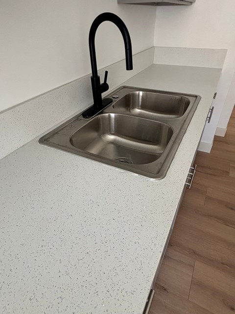 A kitchen sink with a black faucet.