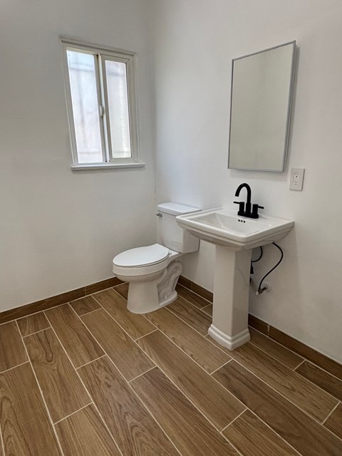 A white toilet sits next to a sink in a bathroom.