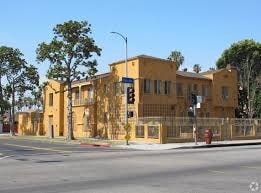 A yellow building is situated on a street corner with a traffic light in front of it.