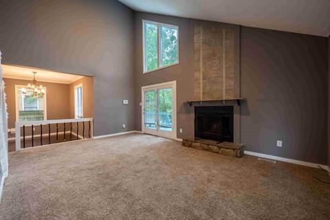 A living room with a fireplace and a large window.