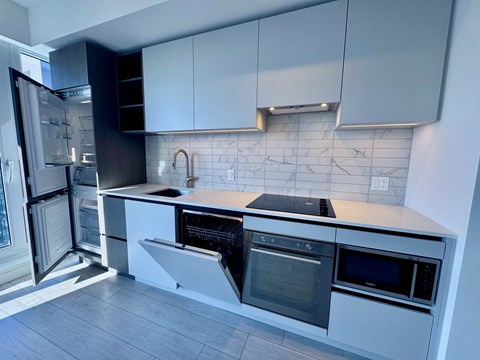 A kitchen with white cabinets and black appliances.