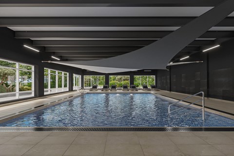 A large indoor swimming pool with a metal ladder on the right side.