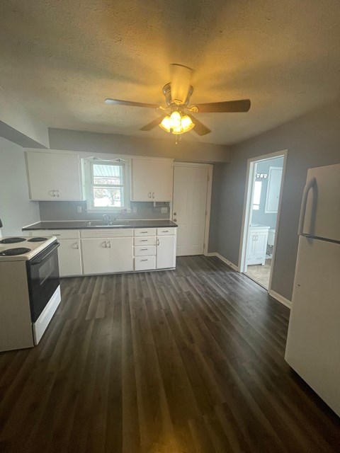 A kitchen with white cabinets and a black stove top oven.
