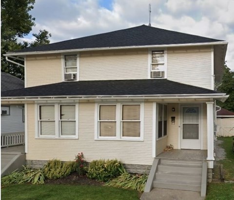 A house with a white front door and a small porch.