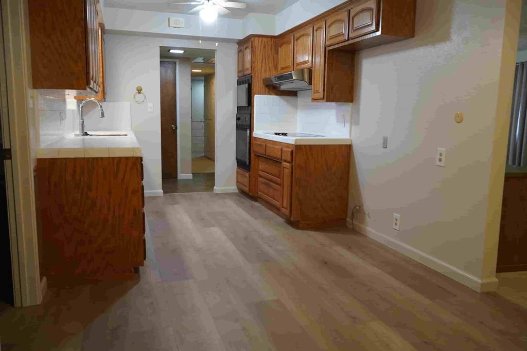 A kitchen with wooden cabinets and a refrigerator.