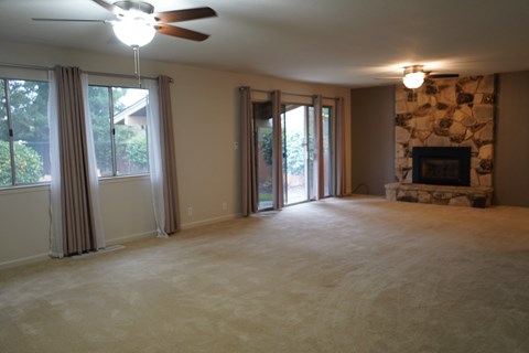 A living room with a fireplace and sliding glass doors.