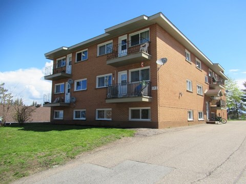 A large brick building with multiple balconies and windows.