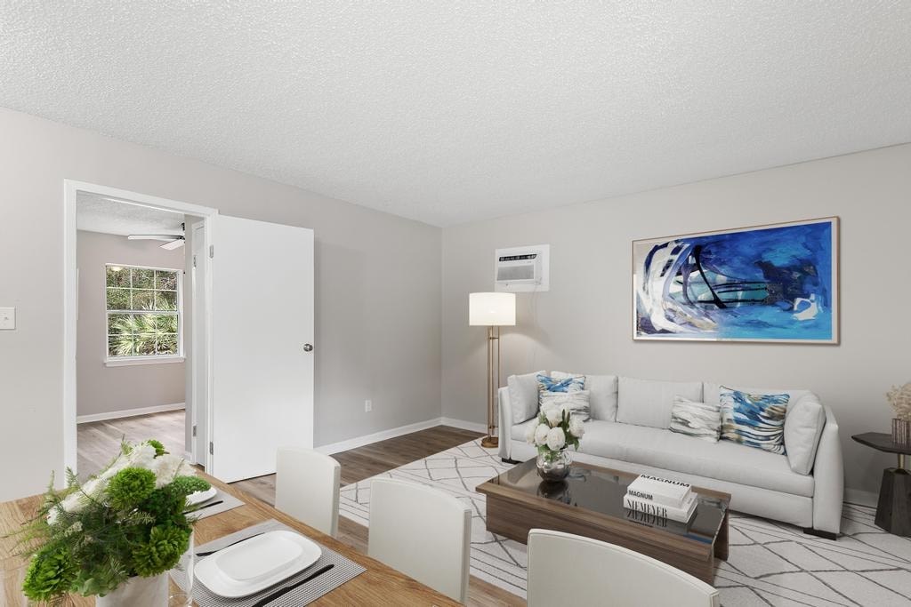 A living room with a white couch and a painting on the wall.