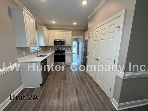 A kitchen with white cabinets and a black stove top oven.
