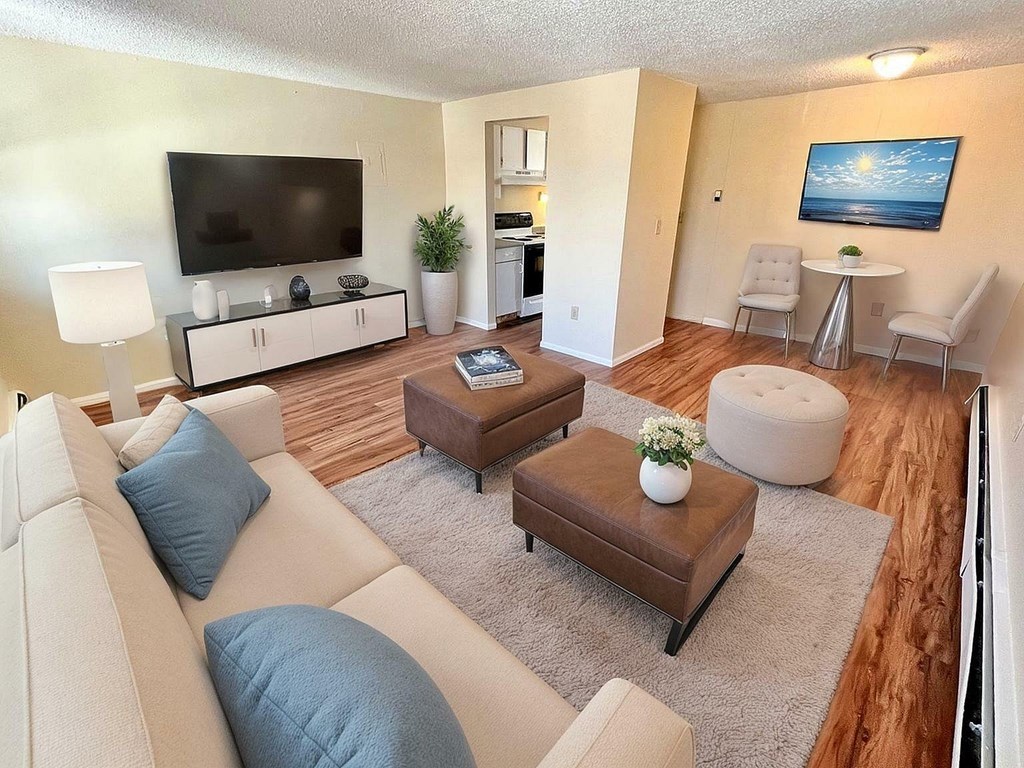 A street view of a residential area with a beige building in the foreground.