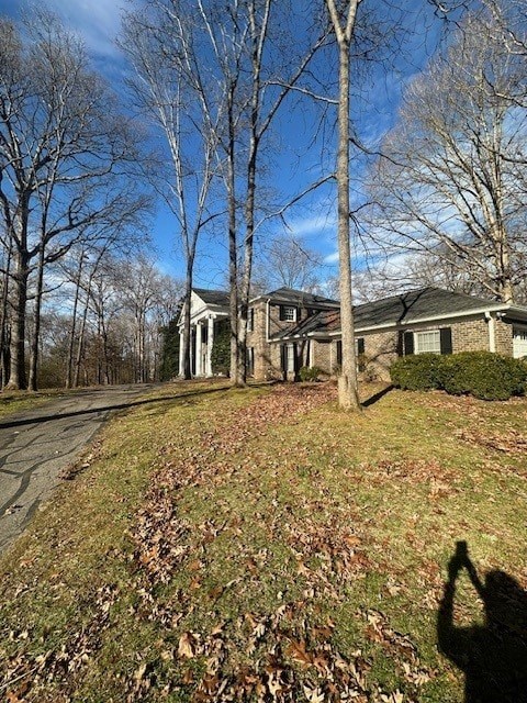 A house with a driveway and trees in front.
