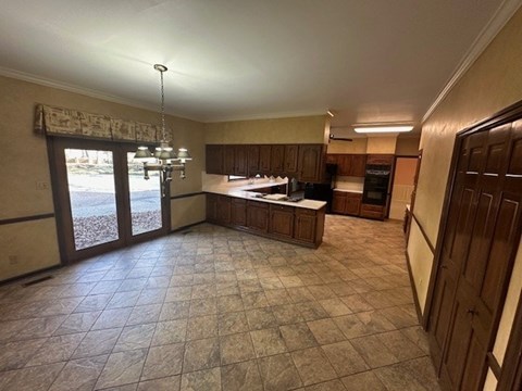 A kitchen with tile flooring and wooden cabinets.