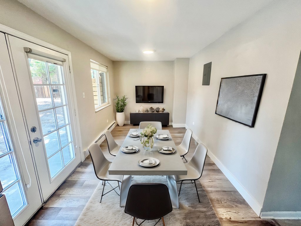 A dining room with a table set for a meal.