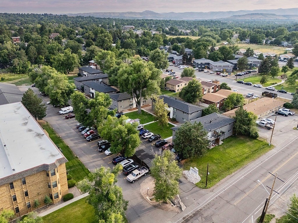 A parking lot with cars and buildings in the background.