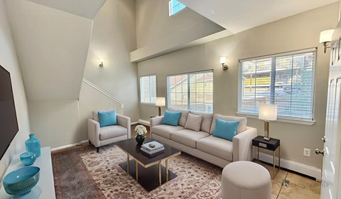 A living room with a couch, chairs, and a coffee table.